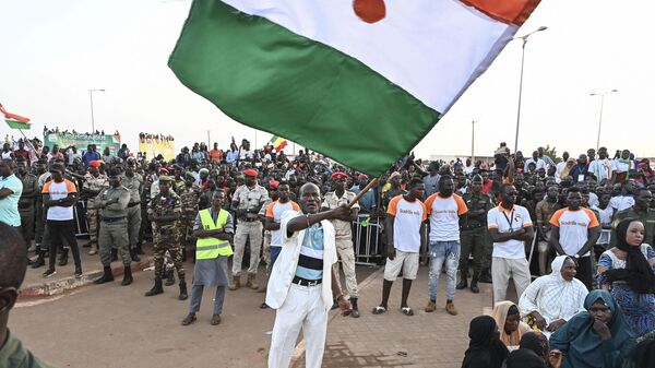 Apoiador do Conselho Nacional para a Salvaguarda da Pátria (CNSP) do Níger segura uma bandeira do Níger enquanto participa de comício de apoio ao Exército, em 10 de setembro de 2023 - Sputnik Brasil