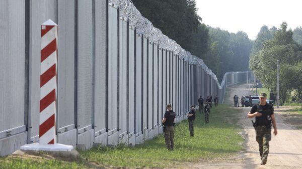Guardas de fronteira poloneses patrulham a área de um muro de metal construído na fronteira entre a Polônia e Belarus, perto de Kuznice, em 30 de junho de 2022 - Sputnik Brasil