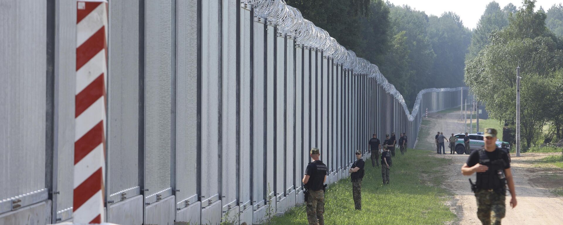 Guardas de fronteira poloneses patrulham a área de um muro de metal recém-construído na fronteira entre a Polônia e Belarus, perto de Kuznice, Polônia, em 30 de junho de 2022 - Sputnik Brasil, 1920, 22.11.2023