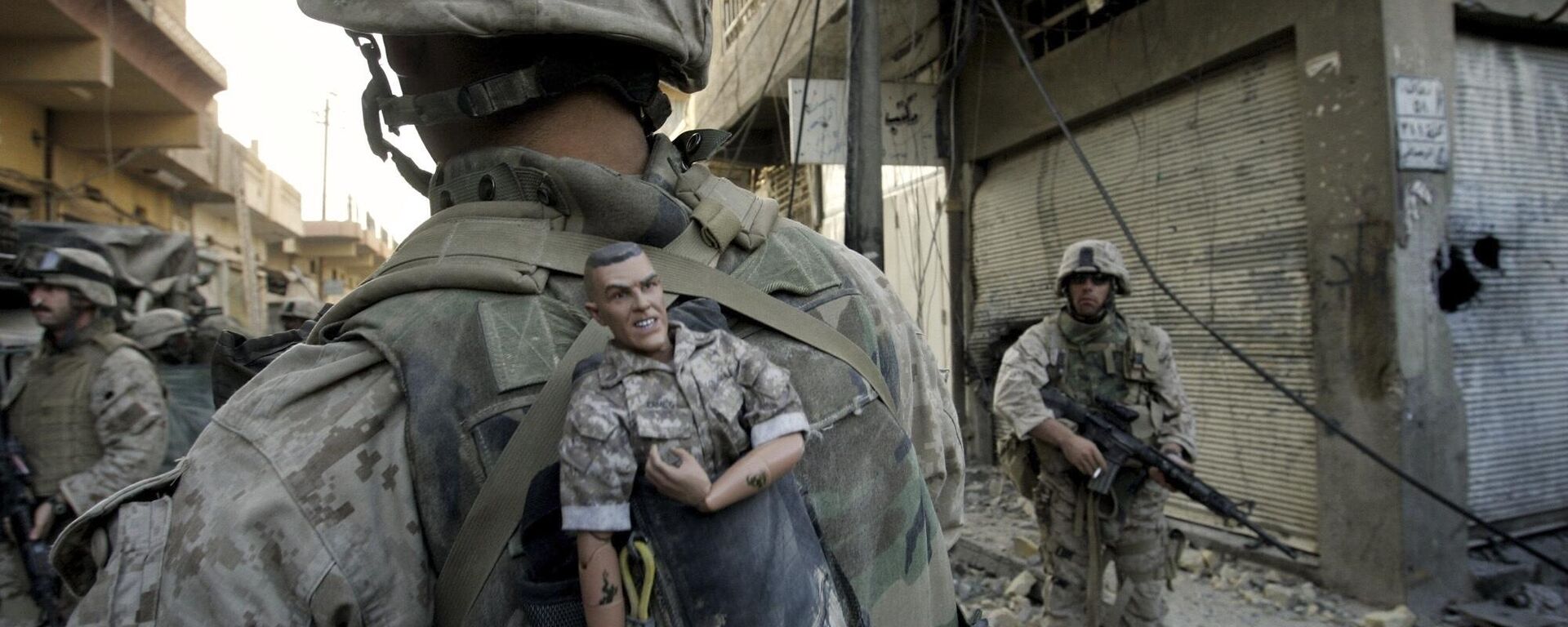 Um fuzileiro naval da 1ª Divisão dos EUA carrega um mascote para dar sorte em sua mochila enquanto sua unidade avança na parte ocidental de Fallujah, Iraque, 14 de novembro de 2004 - Sputnik Brasil, 1920, 31.05.2024