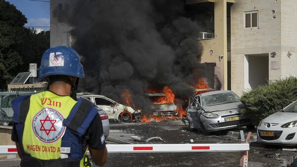 Carros em chamas após um foguete disparado a partir da Faixa de Gaza atingir um estacionamento e um prédio residencial na cidade de Ashkelon, no sul de Israel, 7 de outubro de 2023 - Sputnik Brasil