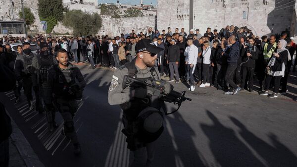 Palestinos observam enquanto as forças de segurança israelenses patrulham perto do Portão de Damasco, nos arredores da Cidade Velha de Jerusalém, 20 de abril de 2022 - Sputnik Brasil