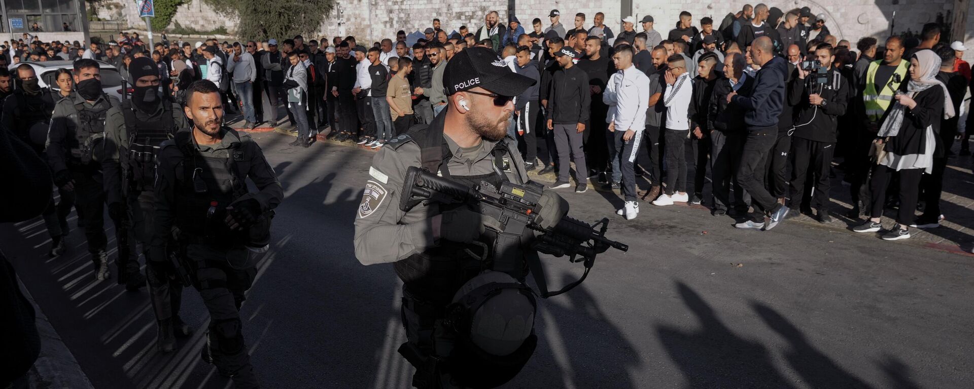 Palestinos observam enquanto as forças de segurança israelenses patrulham perto do Portão de Damasco, nos arredores da Cidade Velha de Jerusalém, 20 de abril de 2022 - Sputnik Brasil, 1920, 08.10.2023