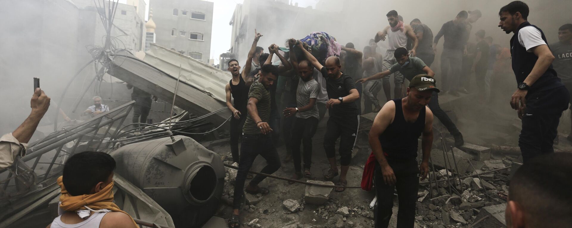 Palestinos removem um cadáver dos escombros de um prédio após um ataque aéreo israelense. Faixa de Gaza, 9 de outubro de 2023 - Sputnik Brasil, 1920, 09.10.2023