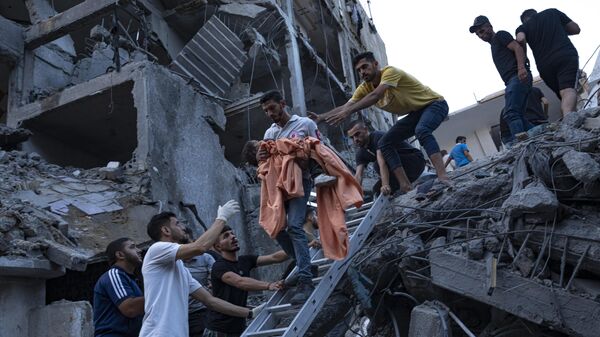 Criança resgatada em meio aos destroços após ataque de Israel que destruiu prédio. Faixa de Gaza, 10 de outubro de 2023 - Sputnik Brasil