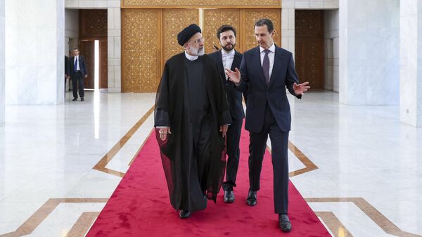 O presidente Ebrahim Raisi, à esquerda, ouve seu homólogo sírio, Bashar Assad, durante uma cerimônia de boas-vindas em Damasco, Síria, 3 de maio de 2023 - Sputnik Brasil