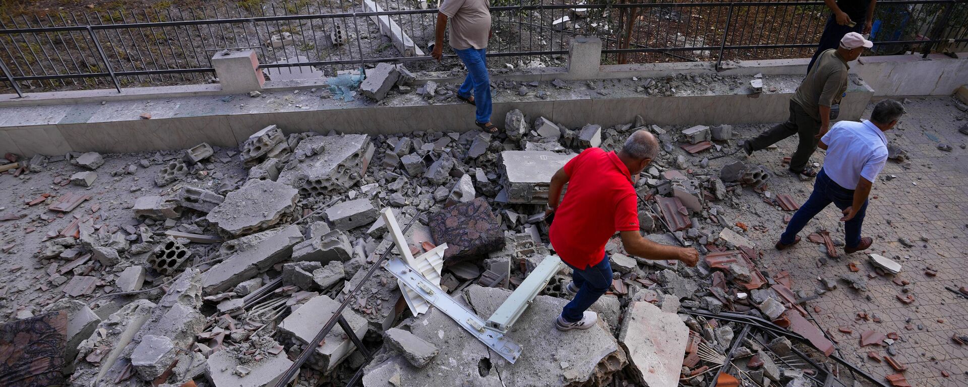 Homens libaneses verificam uma casa danificada que foi atingida por bombardeios israelenses na vila de Duhaira, na fronteira com Israel. Líbano, 12 de outubro de 2023 - Sputnik Brasil, 1920, 21.10.2023