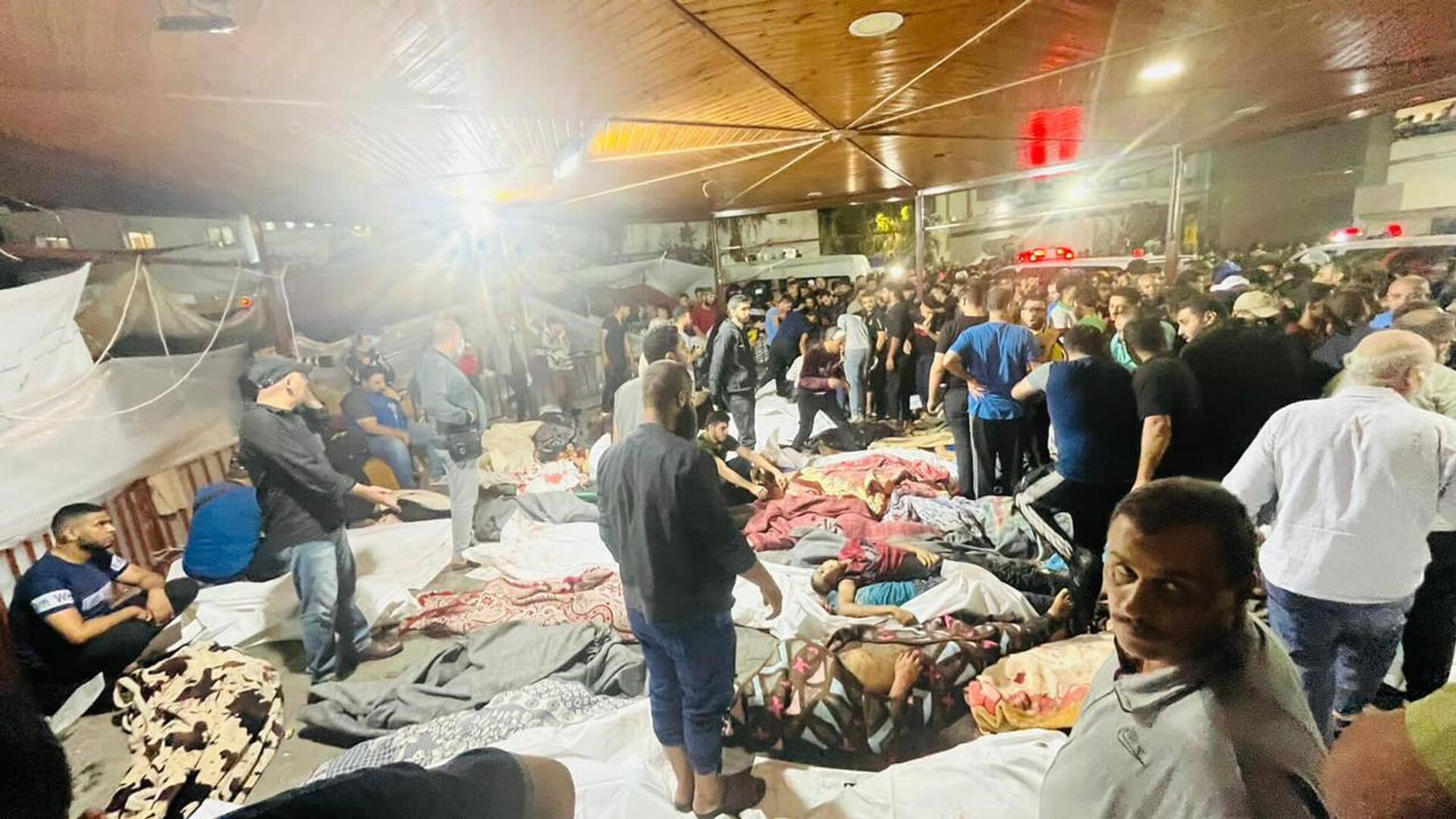 Refugiados palestinos dentro de instalações próximas ao Hospital Batista al-Ahli, localizado em Gaza e bombardeado em 17 de outubro de 2023 - Sputnik Brasil, 1920, 17.10.2023