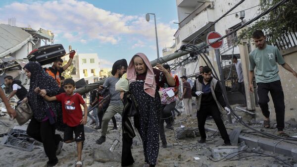 Famílias palestinas fogem de suas casas após bombardeios israelenses. Gaza, 18 de outubro de 2023 - Sputnik Brasil