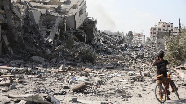 Um menino palestino olha para os edifícios destruídos no bombardeio israelense em Al-Zahra, nos arredores da cidade de Gaza, 20 de outubro de 2023 - Sputnik Brasil