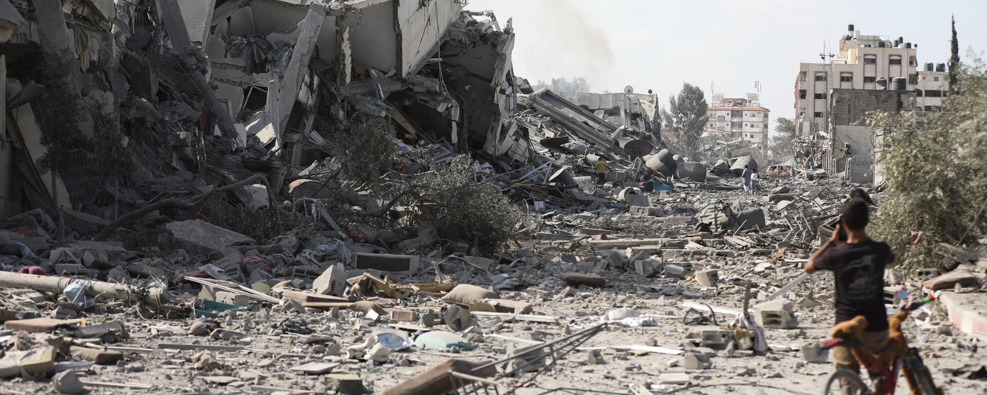 Menino palestino diante de edifícios destruídos por bombardeio israelense em Al-Zahra, nos arredores da cidade de Gaza, em 20 de outubro de 2023 - Sputnik Brasil, 1920, 20.10.2023