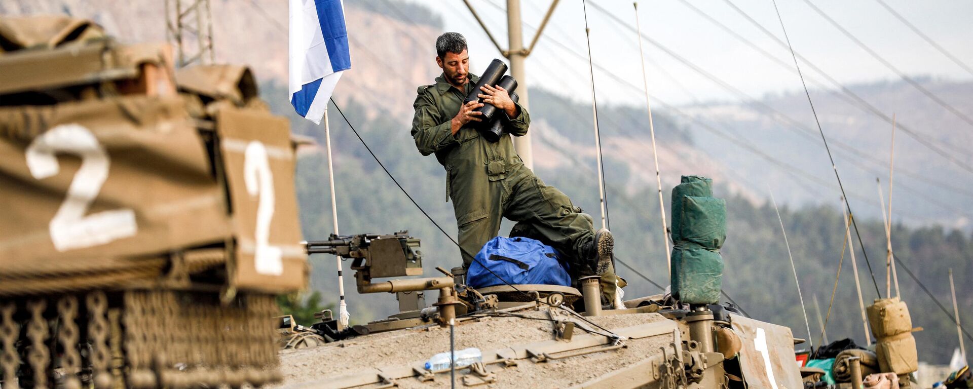 Soldado do Exército israelense segura projéteis no alto de um tanque Merkava, em meio a concentração de tanques na alta Galileia, no norte de Israel, perto da fronteira com o Líbano, em 11 de outubro de 2023 - Sputnik Brasil, 1920, 30.10.2023