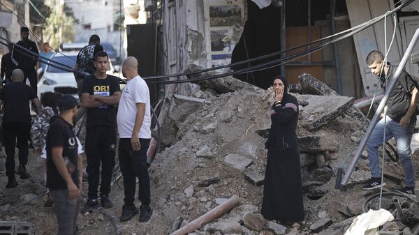 Pessoas olham para a destruição deixada por ataque do Exército israelense contra um campo de refugiados palestinos localizado na Cisjordânia. Israel, 20 de outubro de 2023 - Sputnik Brasil