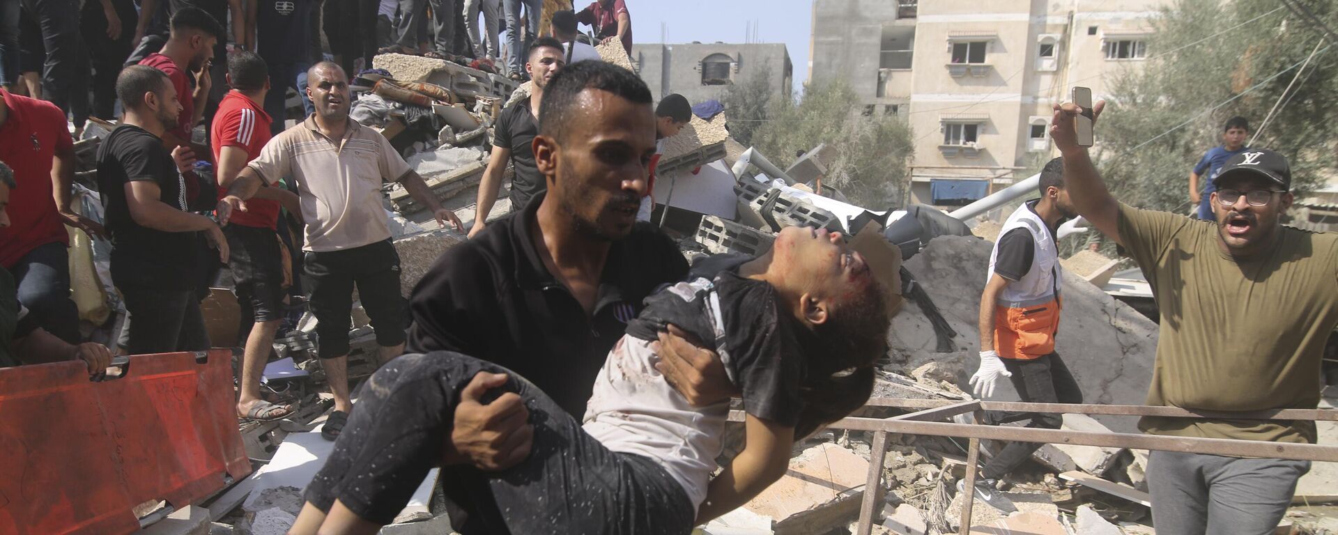 Palestinos tentam salvar pessoas que ficaram feridas após bombardeio israelense em área residencial na Faixa de Gaza. Rafah, 23 de outubro de 2023 - Sputnik Brasil, 1920, 30.10.2023