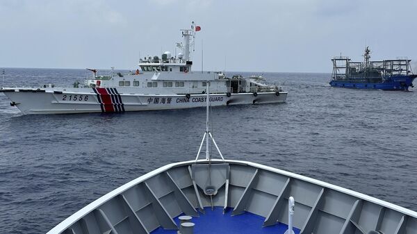 Navio da Guarda Costeira chinesa (à esquerda), com uma embarcação da milícia chinesa (à direita), bloqueia navio da Guarda Costeira das Filipinas, BRP Sindangan, enquanto este tentava se dirigir ao Second Thomas Shoal no disputado mar do Sul da China, durante missão de rotação e reabastecimento em 4 de outubro de 2023 - Sputnik Brasil