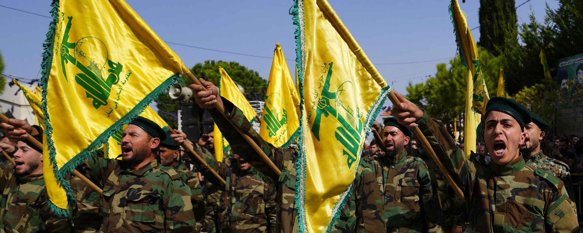 Combatentes do Hezbollah levantam a bandeira de seu grupo e entoam gritos de guerra enquanto assistem ao cortejo fúnebre do combatente do Hezbollah Bilal Nemr Rmeiti, morto por bombardeios israelenses, em 22 de outubro de 2023 - Sputnik Brasil, 1920, 02.11.2023
