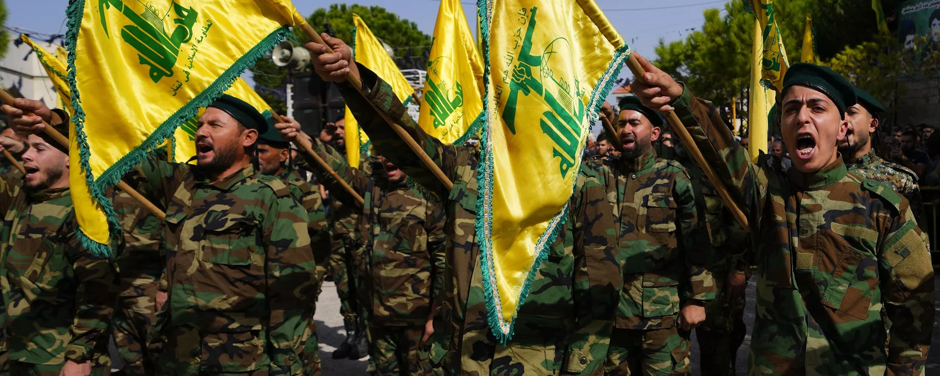 Combatentes do Hezbollah levantam a bandeira do grupo e entoam gritos de guerra enquanto assistem ao cortejo fúnebre do combatente Bilal Nemr Rmeiti, morto por bombardeios israelenses, em 22 de outubro de 2023 - Sputnik Brasil, 1920, 21.08.2024