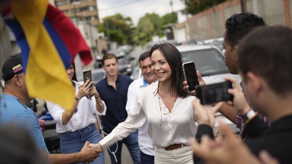 Apoiadores cumprimentam a candidata presidencial da oposição, Maria Corina Machado, em seção eleitoral para votar durante as eleições primárias da oposição em Caracas, Venezuela, domingo, 22 de outubro de 2023. - Sputnik Brasil