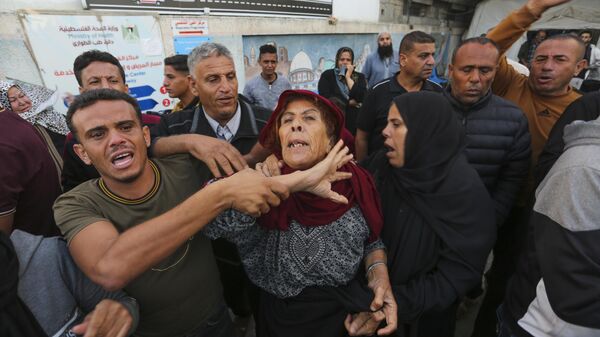 Palestinos buscam parentes após bombardeio israelense em Rafah. Faixa de Gaza, 7 de novembro de 2023 - Sputnik Brasil