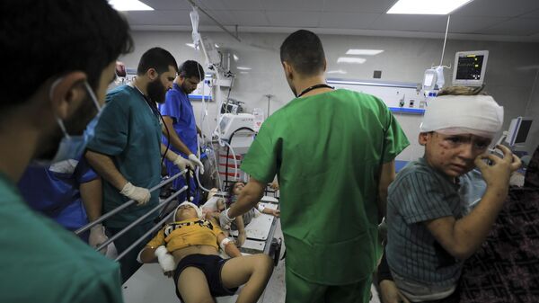 Médico palestino trata feridos após bombardeio israelense no hospital Al-Shifa. Gaza, 23 de outubro de 2023 - Sputnik Brasil