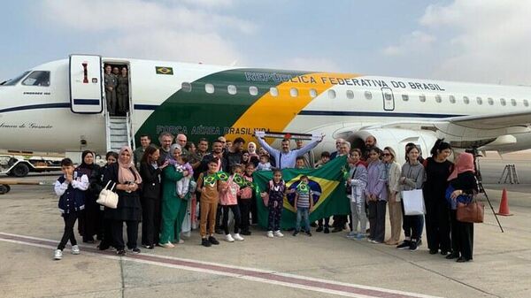 Grupo de repatriados reunido em frente ao avião presidencial da FAB no Aeroporto Internacional do Cairo, momentos antes da partida para o Brasil. Egito, 13 de novembro de 2023 - Sputnik Brasil