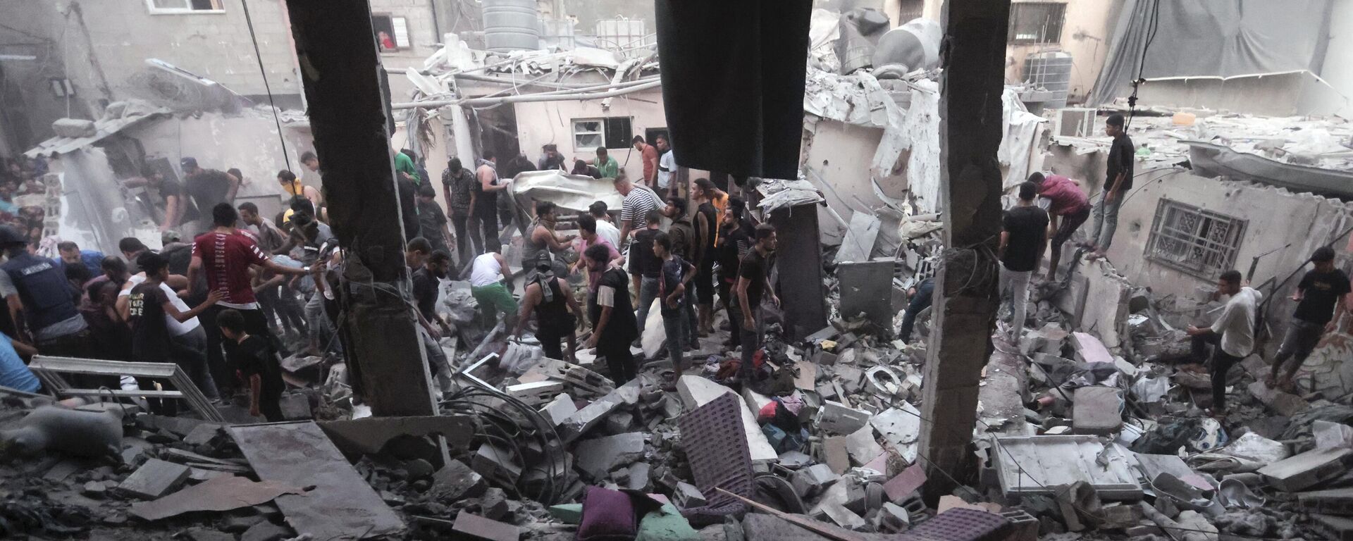 Palestinos em meio à destruição provocada por ataque aéreo israelense em campo de refugiados na Faixa de Gaza. Khan Yunis, 13 de novembro de 2023 - Sputnik Brasil, 1920, 13.11.2023