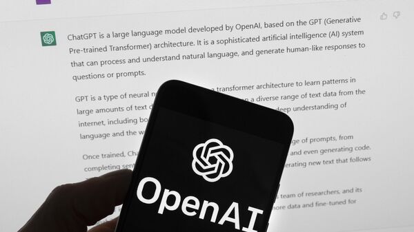 O logotipo OpenAI é visto em um telefone celular na frente de uma tela de computador que exibe a saída do ChatGPT, em Boston. EUA, 21 de março de 2023 - Sputnik Brasil