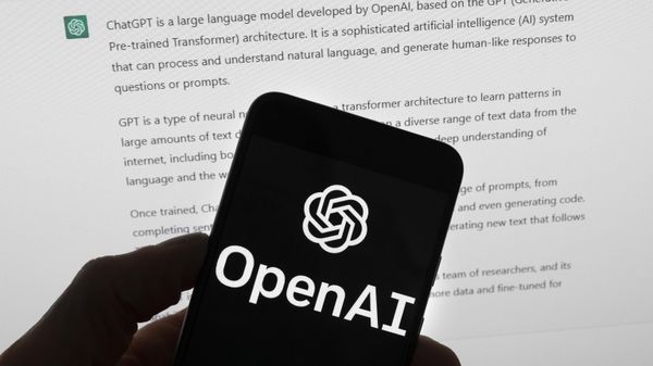 Logotipo da OpenAI, empresa criadora do ChatGPT, em celular sobre tela de computador que exibe o chatbot. Boston, EUA, 21 de março de 2023 - Sputnik Brasil