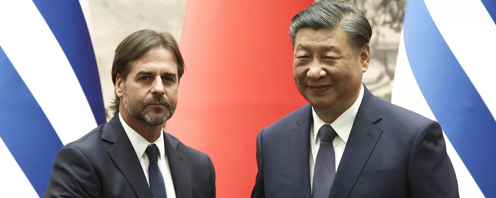 O presidente do Uruguai, Luis Lacalle Pou, e o presidente da China, Xi Jinping, apertam as mãos durante uma cerimônia de assinatura no Grande Salão do Povo em Pequim, em 22 de novembro de 2023 - Sputnik Brasil, 1920, 22.11.2023