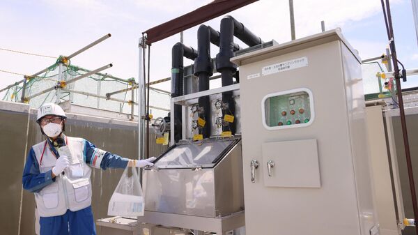Um funcionário apresenta um equipamento para amostragem de água, a fim de analisar a concentração de trítio radioativo antes de descarregar a água tratada diluída como parte da instalação para a liberação de água tratada da usina nuclear de Fukushima. Okuma, 27 de agosto de 2023 - Sputnik Brasil