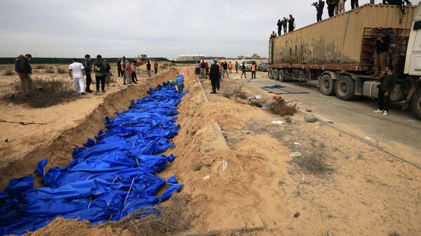Palestinos enterram corpos em uma vala comum no cemitério Khan Yunis. Faixa de Gaza, 22 de novembro de 2023 - Sputnik Brasil