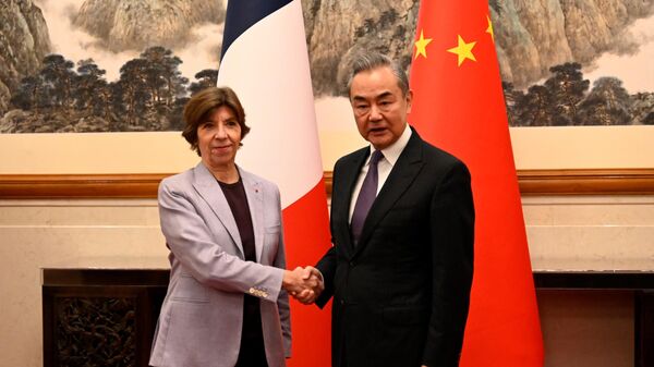O ministro das Relações Exteriores da China, Wang Yi, aperta a mão da ministra das Relações Exteriores da França, Catherine Colonna, antes de reunião na Casa de Hóspedes do Estado de Diaoyutai, em Pequim, em 24 de novembro de 2023 - Sputnik Brasil