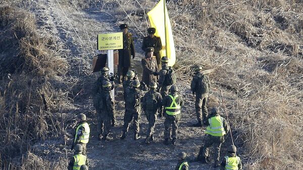 Soldado do Exército da Coreia do Sul aperta a mão de soldado do Exército da Coreia do Norte antes de cruzar a Linha de Demarcação Militar, dentro da Zona Desmilitarizada, para inspecionar o posto de guarda norte-coreano desmontado na seção central da fronteira intercoreana em Cheorwon, em 12 de dezembro de 2018 - Sputnik Brasil
