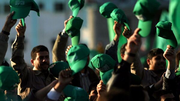 Os apoiadores palestinos do Hamas erguem seus chapéus verdes durante uma manifestação celebrando a vitória do grupo nas eleições parlamentares, no Campo de Refugiados Khan Yunis, no sul da Faixa de Gaza, em 27 de janeiro de 2006 - Sputnik Brasil