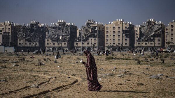 Mulher palestina busca abrigo em Khan Yunis, cidade destruída parcialmente pelos bombardeios israelenses, em 2 de dezembro de 2023 - Sputnik Brasil