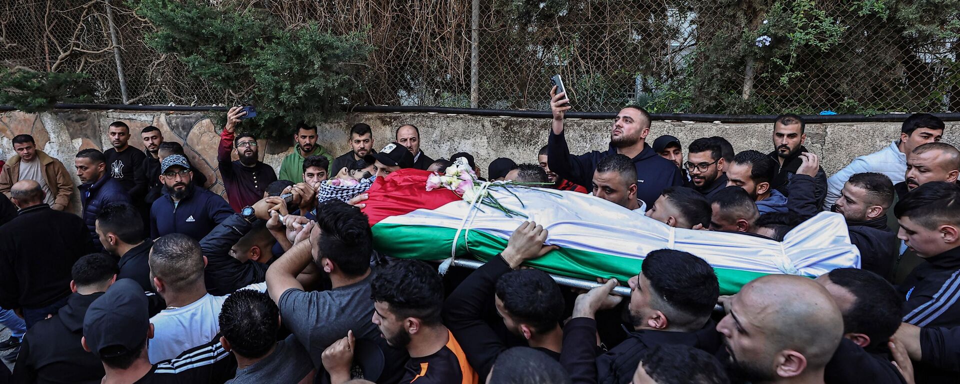 Palestinos carregam corpo de homem morto durante confrontos com as forças israelenses no campo de Qalandia, durante cortejo fúnebre fora do hospital do governo de Ramallah, Cisjordânia, 4 de dezembro de 2023 - Sputnik Brasil, 1920, 04.12.2023