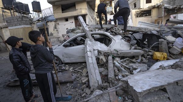 Palestinos inspecionam casa após ela ter sido atingida por um bombardeio israelense em Rafah. Faixa de Gaza, 20 de dezembro de 2023 - Sputnik Brasil