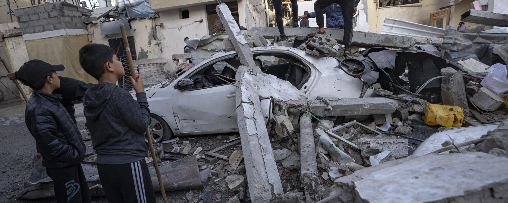 Palestinos inspecionam casa após ela ter sido atingida por um bombardeio israelense em Rafah. Faixa de Gaza, 20 de dezembro de 2023 - Sputnik Brasil, 1920, 13.06.2024
