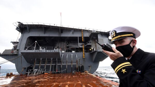 Oficial da Marinha dos EUA fala pelo rádio no convés do porta-aviões de propulsão nuclear USS Harry S. Truman ancorado no porto de Split, Croácia, 14 de fevereiro de 2022 - Sputnik Brasil
