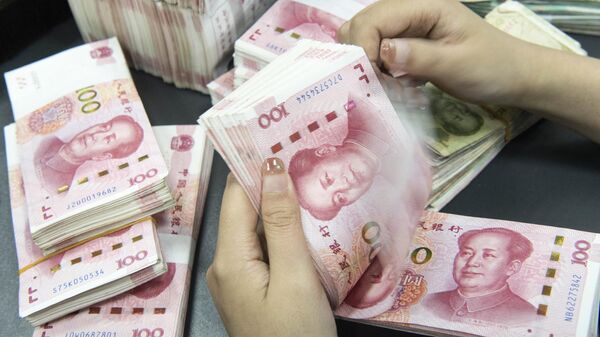 Um funcionário de um banco contando notas de 100 yuans em um balcão de banco em Nantong, na província de Jiangsu, no leste da China, 13 de novembro de 2023 - Sputnik Brasil