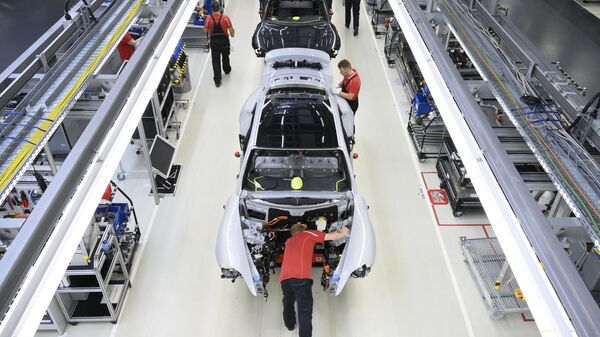 Funcionários da fabricante de automóveis alemã Porsche AG trabalham em carros esportivos elétricos Porsche Taycan na linha de montagem da unidade de produção da Porsche em Stuttgart, sudoeste da Alemanha, 26 de setembro de 2022 - Sputnik Brasil