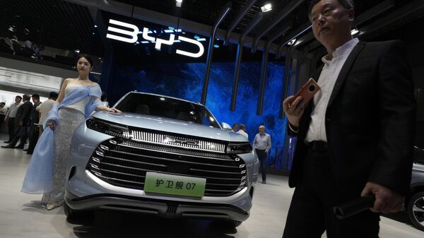 Modelo ao lado de um carro da empresa chinesa BYD durante o Salão do Automóvel de Xangai, em Xangai, China, 18 de abril de 2023 - Sputnik Brasil