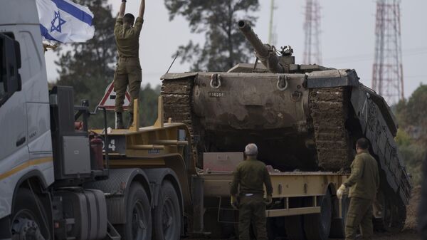Soldados israelenses carregam tanque em caminhão de transporte em área fronteiriça entre Israel e Gaza, no sul de Israel, 2 de janeiro de 2024 - Sputnik Brasil
