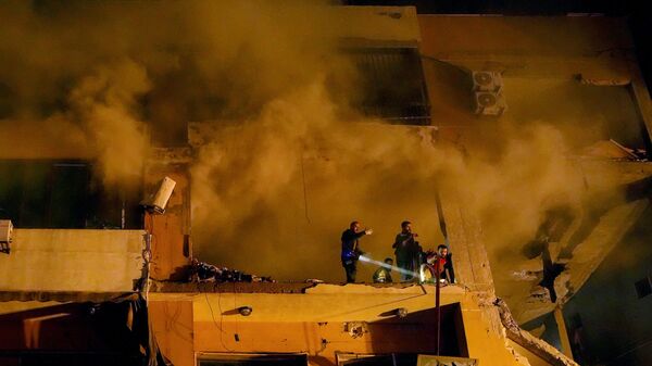 A fumaça sobe de um apartamento destruído enquanto trabalhadores da Defesa Civil procuram por sobreviventes após uma grande explosão no subúrbio de Dahiyeh, no sul de Beirute. Líbano, 2 de janeiro de 2024 - Sputnik Brasil
