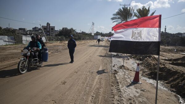 Palestinos passam uma bandeira egípcia na lateral de uma rua em Beit Lahiya, norte da Faixa de Gaza, em 25 de janeiro de 2022. - Sputnik Brasil