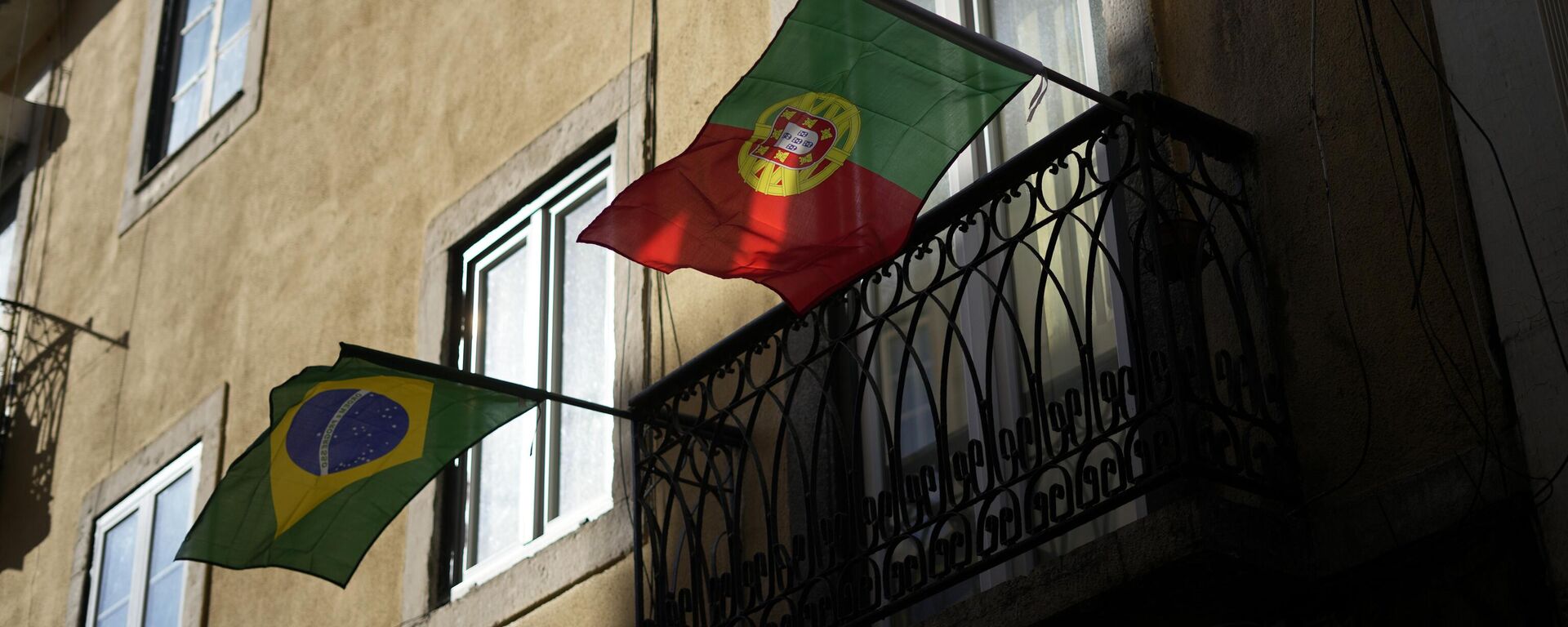 As bandeiras do Brasil e de Portugal penduradas lado a lado em uma varanda em Lisboa. 1º de fevereiro de 2023 - Sputnik Brasil, 1920, 03.06.2025