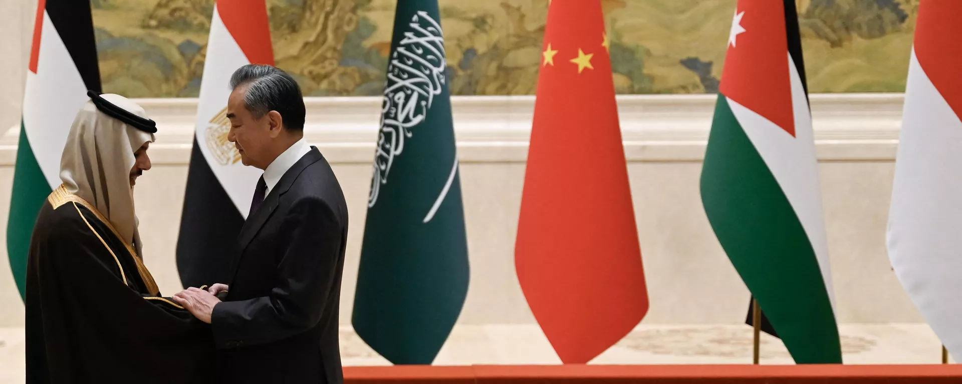 O ministro das Relações Exteriores da China, Wang Yi (R), aperta a mão do ministro das Relações Exteriores da Arábia Saudita, príncipe Faisal bin Farhan Al-Saud, antes de uma foto de família para os participantes de uma reunião de ministros das Relações Exteriores de países de maioria árabe e muçulmana na Casa de Hóspedes do Estado de Diaoyutai, em Pequim em 20 de novembro de 2023 - Sputnik Brasil, 1920, 18.01.2024