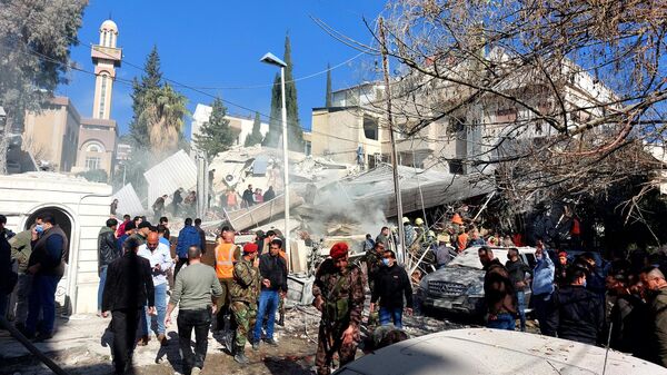 Moradores e forças de segurança se reúnem em frente a prédio destruído em um ataque israelense em Damasco, Síria, 20 de janeiro de 2024 - Sputnik Brasil