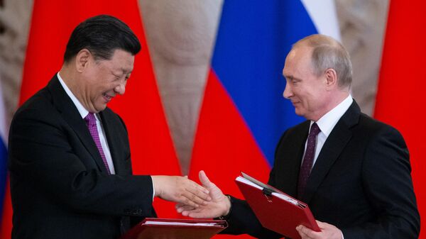 O presidente russo, Vladimir Putin, e seu homólogo chinês, Xi Jinping, trocam documentos durante uma cerimônia de assinatura após suas conversações no Kremlin, em Moscou (foto de arquivo) - Sputnik Brasil