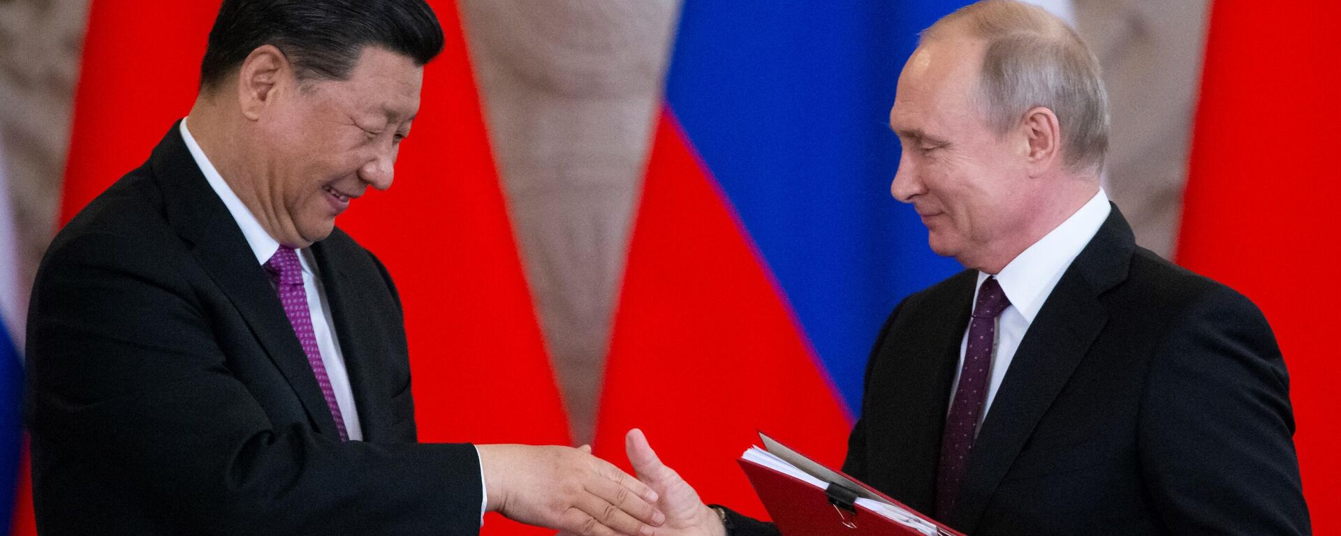 O presidente russo, Vladimir Putin, e seu homólogo chinês, Xi Jinping, trocam documentos durante uma cerimônia de assinatura após suas conversações no Kremlin, em Moscou (foto de arquivo) - Sputnik Brasil, 1920, 20.01.2024